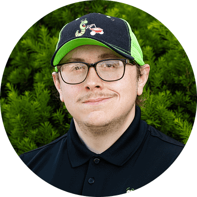 Green lawn care technician wearing Ecolawn branded cap and polo shirt outdoors.